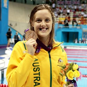 An image of Ellie Cole holding her bronze medal