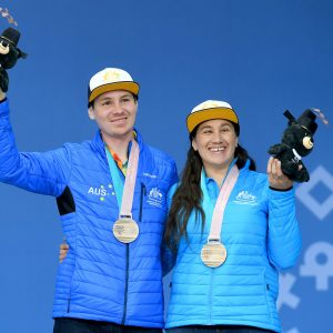 An image of Melissa Perrine and Christian Geiger wearing their medals and smiling