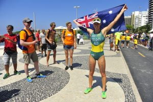An image of Kate Doughty smiling and holding up the Australian flag