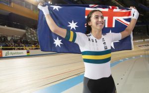 An image of para-cyclist Paige Greco smiling and holding the Australia flag