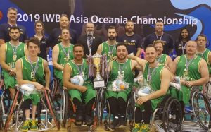 An image of a para-athlete team with the winners cup and medals