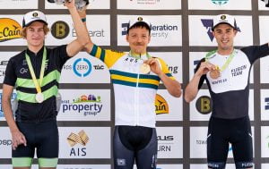 Image of three male athletes posing with their medals and smiling.