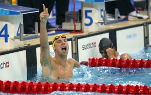 Male paralympic swimmer celebrates winning a race