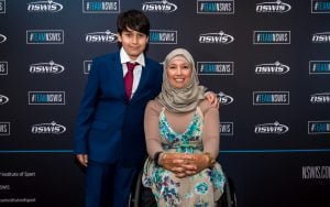 Image of female in a wheelchair - Para archer Ameera Lee - and her son, Huthaifa, standing next to her