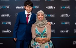 Image of female in a wheelchair - Para archer Ameera Lee - and her son, Huthaifa, standing next to her