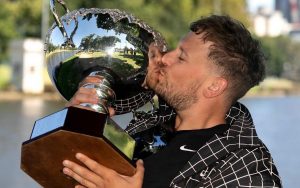 Australian wheelchair tennis player Dylan Alcott holding a trophy and kissing it