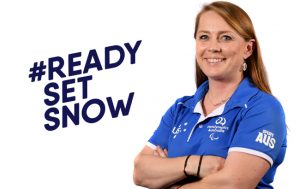 Image of Kate McLoughlin wearing a blue polo shirt with her arms folded across her chest. She is smiling at the camera. Text on the left of the image reads: Ready Set Snow.