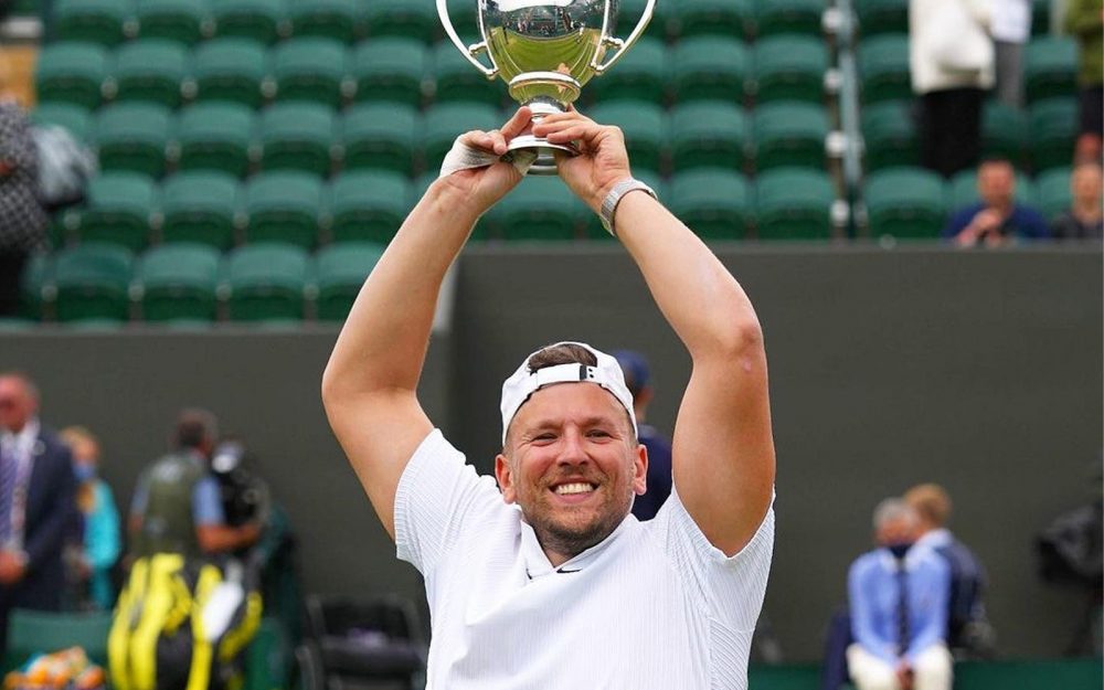 Australian wheelchair tennis player Dylan Alcott lifts the Wimbledon trophy above his head in celebration