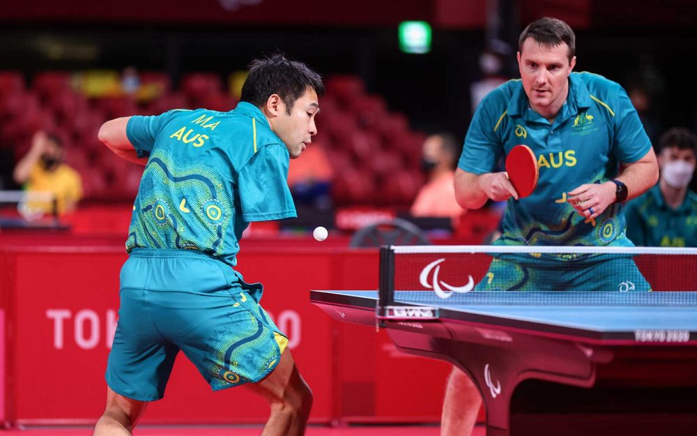 2 male table tennis players play a doubles match