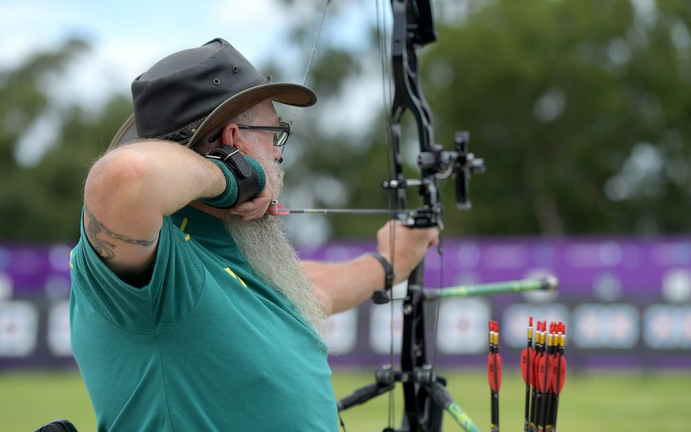 Male Australian Para-archer Peter Marchant lining up to shoot an arrow.
