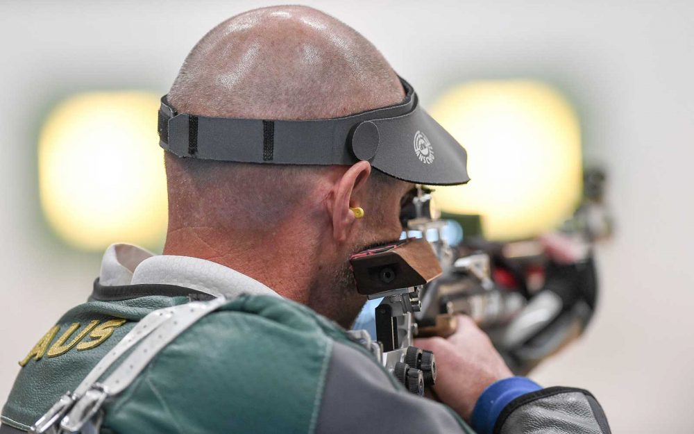 A male focusses on a target during a shooting competition.