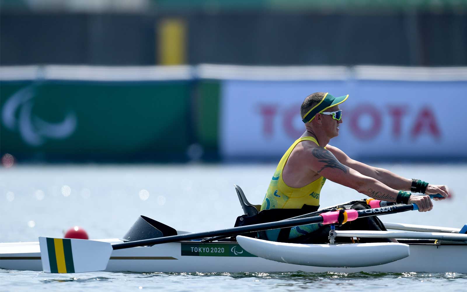 Male rowing boat wearing white sunglasses and visor
