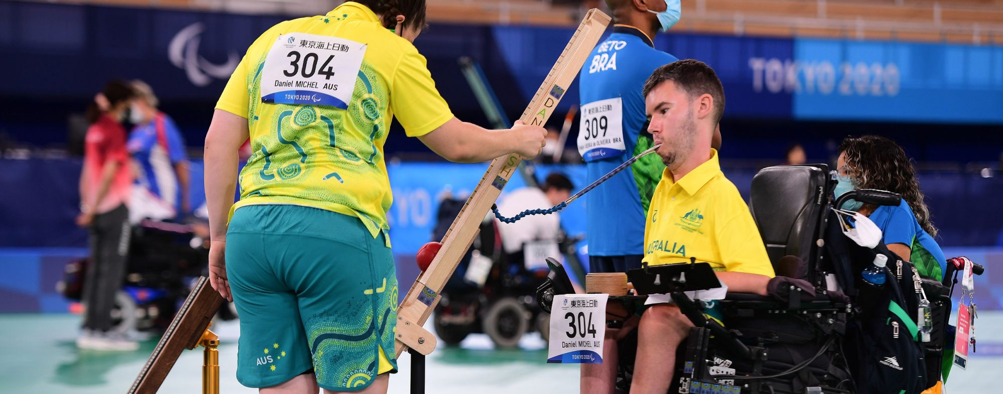 A male Australian Boccia player and female ramp assistant