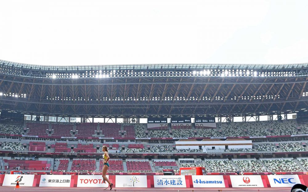 An athlete stands in the middle of an empty stadium