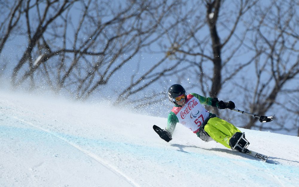 Male athlete competing in Para-alpine skiing