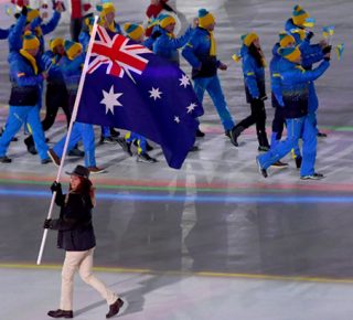 Australian Paralympian Joany Badenhorst carrying the Australian flag with the Ukraine Paralympic Team in the background