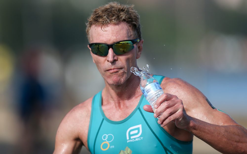 Gerrard Gosens running with a water bottle and sunglasses