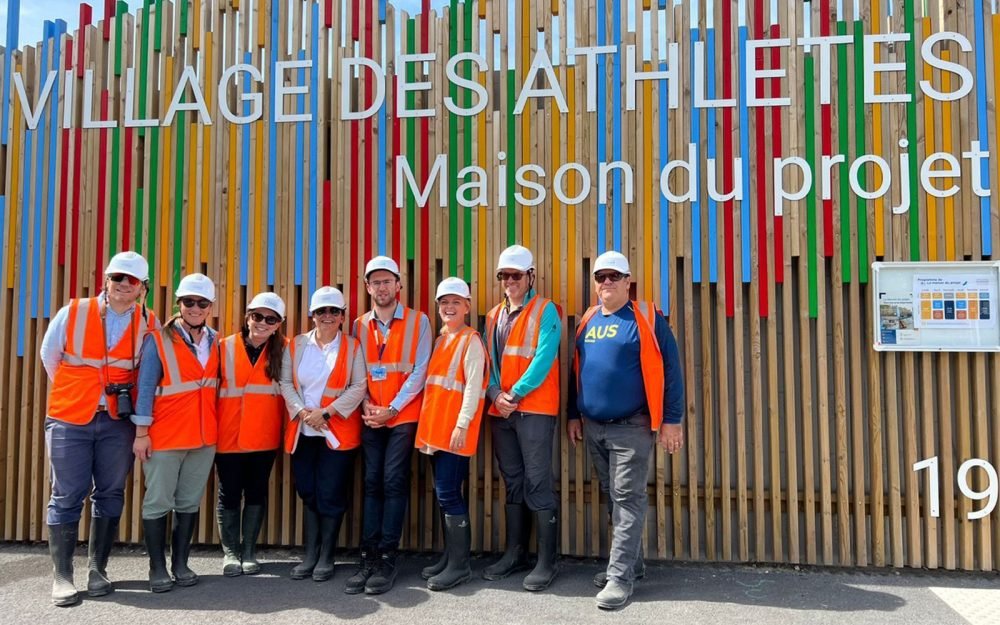 A group of people in high vis orange vests and white helmets.