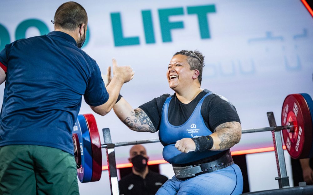 Para-powerlifter Hani Watson high fiving her coach