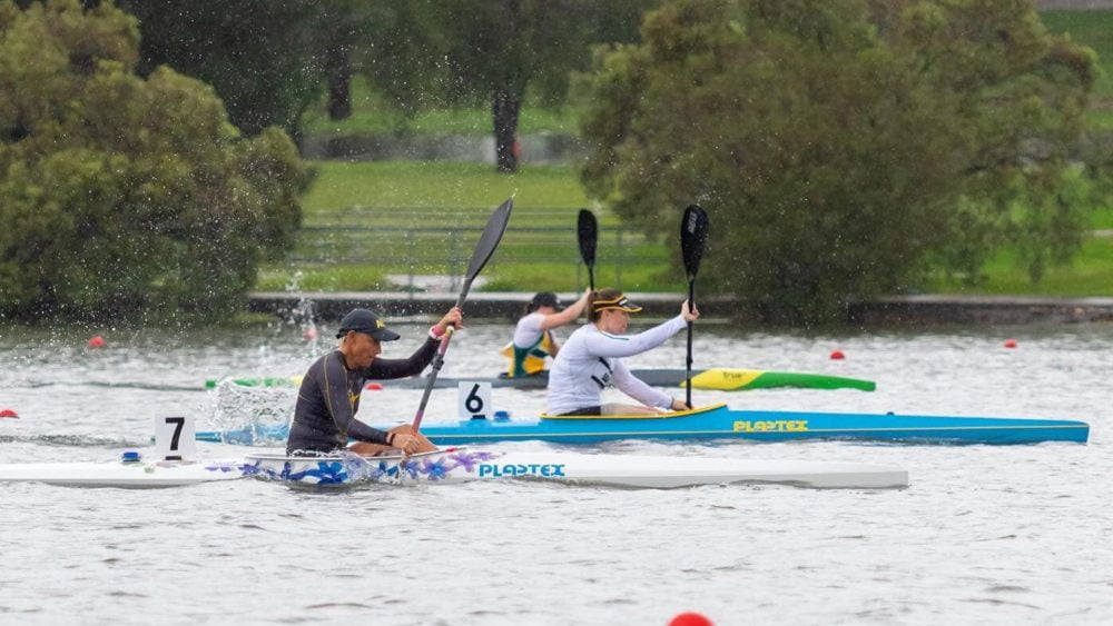 Three athletes canoeing on the water