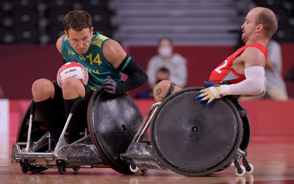 Australian Steelers Wheelchair Rugby player Andrew Edmondson with the ball. He is being defended by a player from Denmark.