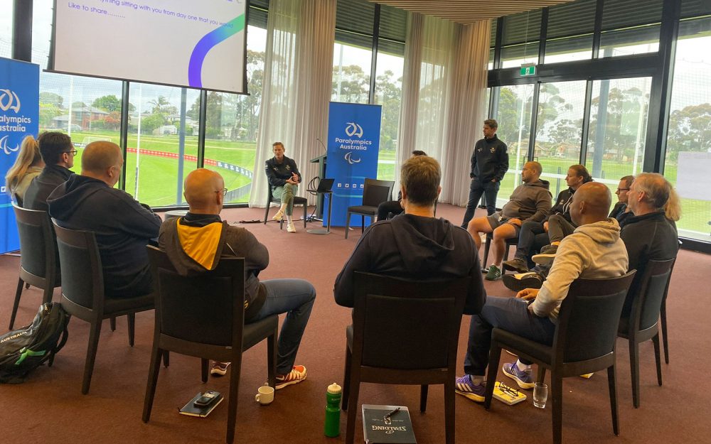 A group of people sitting in a circle and talking.