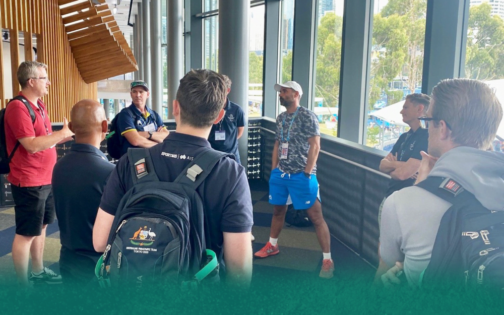 A group of coaches standing in a circle talking