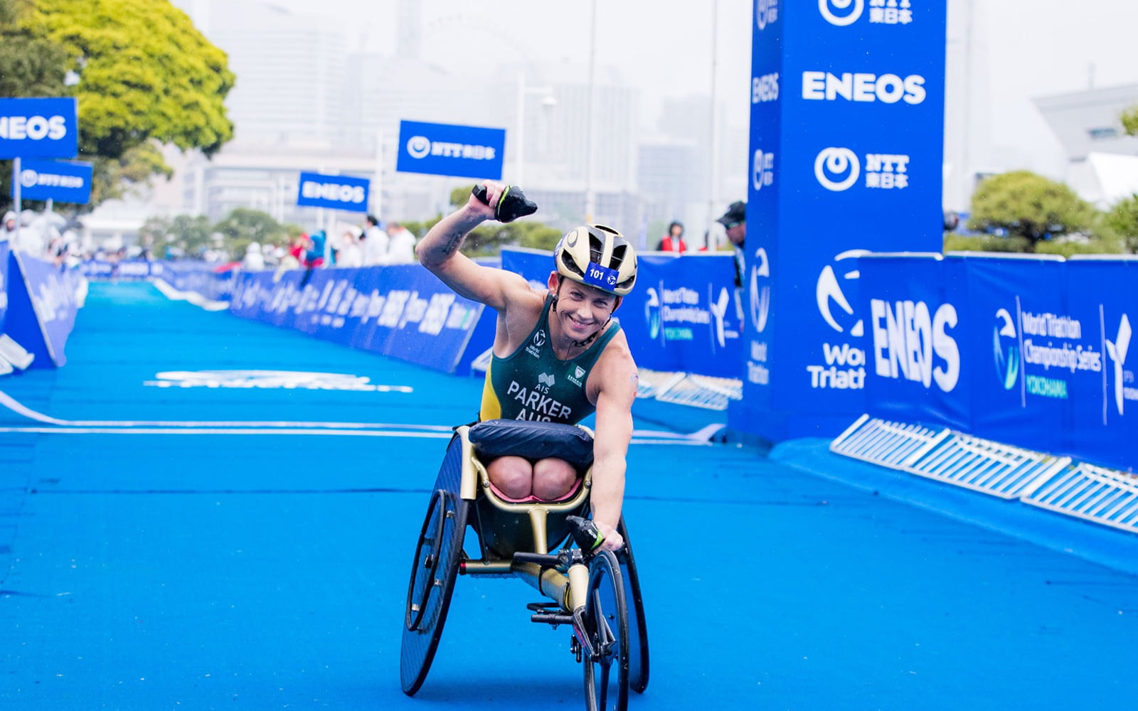 Australian Paralympian Lauren Parker crossing the finish line of a race raising her fits in the air.
