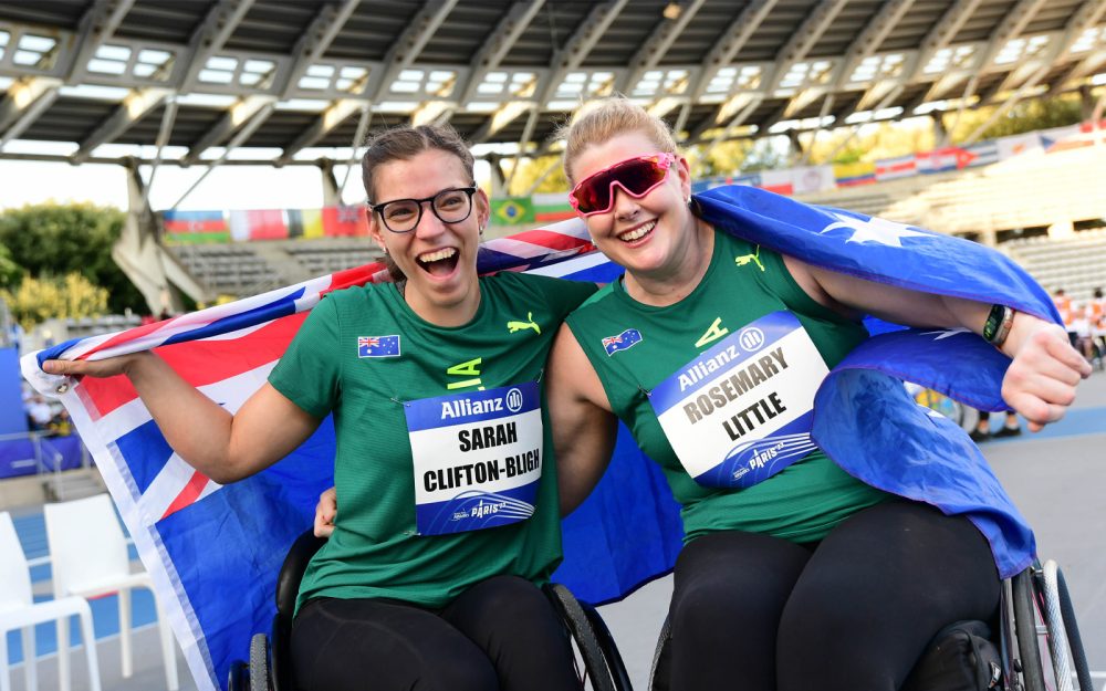 Australian athletics athletes Sarah Clifton-Bligh and Rosemary Little wrap themselves in the Australian flag after the World Para-athletics Shotput final.