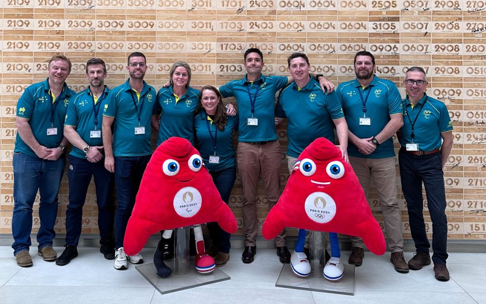 Australian Team Chef de Mission Kate McLoughlin surrounded by leaders of PA's Games' functional areas stand with the Paris 2024 Mascots.