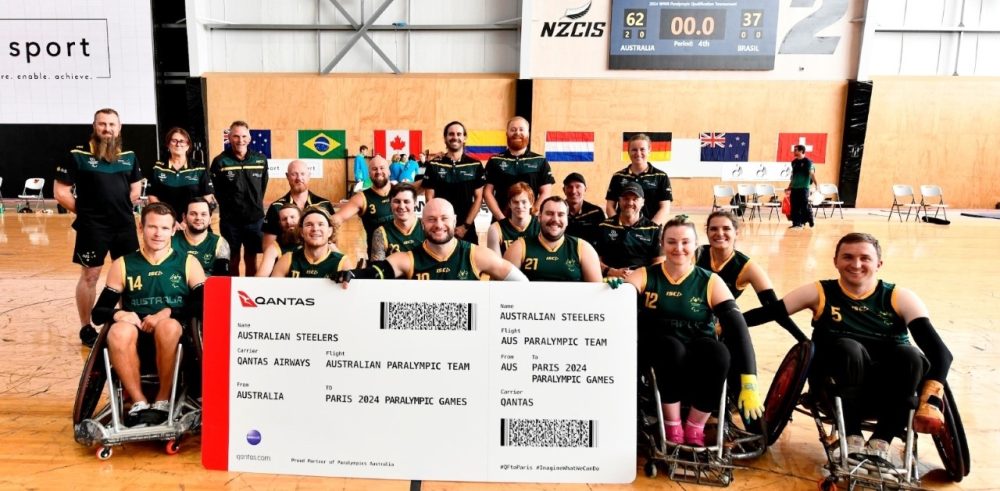 Australian Steelers Wheelchair Rugby Team group shot with oversized Qantas boarding pass.