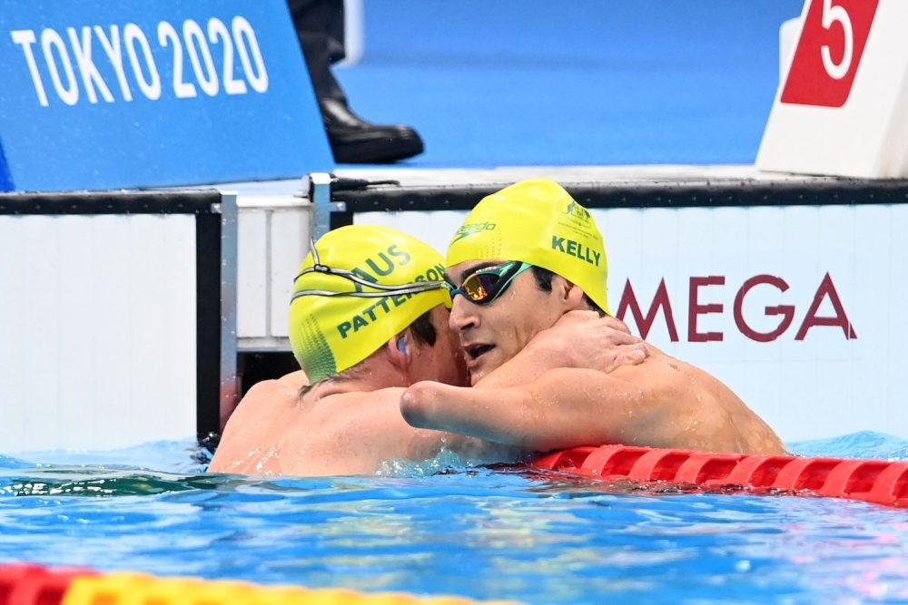 Ahmed Kelly and Grant Patterson embracing after finishing as Para-swimming race