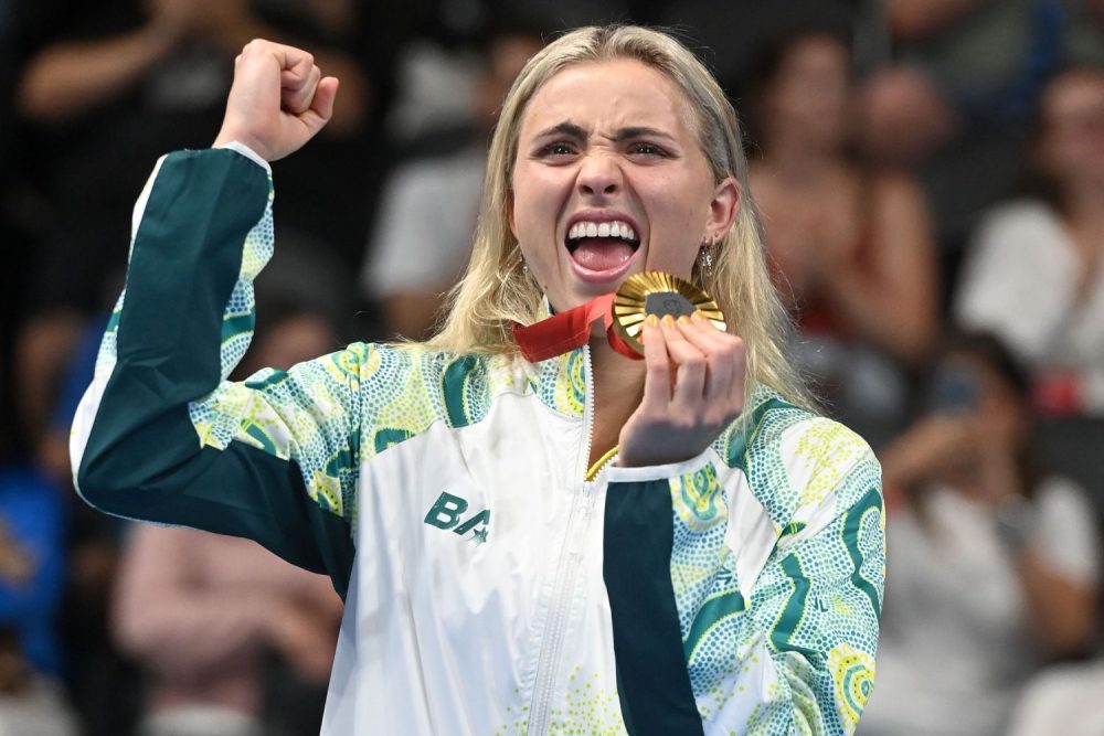 Alexa Leary celebrating her para-swimming gold medal on the podium in Paris.