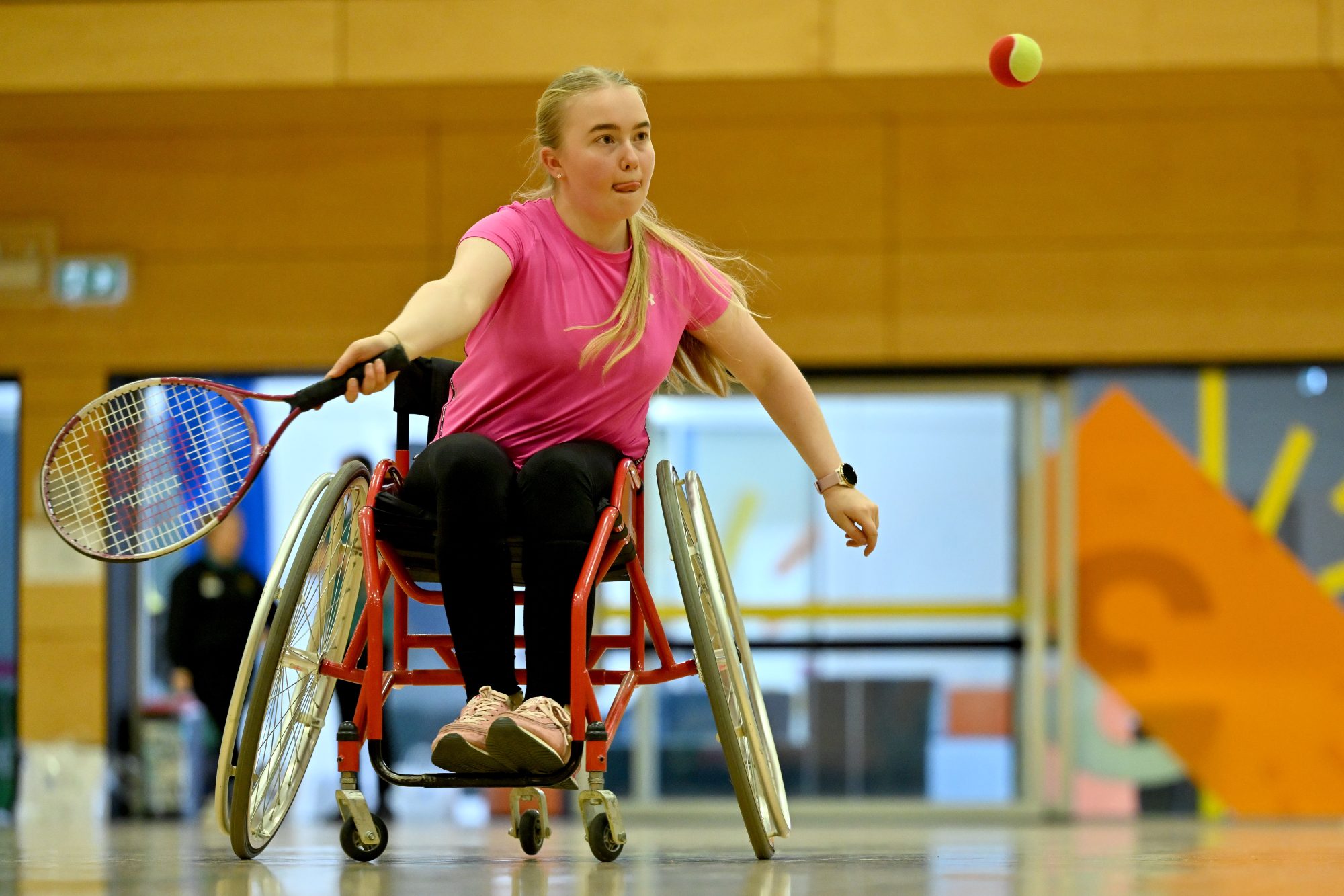 A young female athlete competing in wheelchair tennis