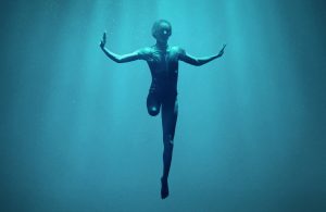 A caucasian woman is suspended underwater, her right leg ends above the knee, she is wearing a swimsuit and has outstretched arms. White text superimposed on the photo that reads "A Netflix Original Documentary Rising Phoenix 26 August Netflix